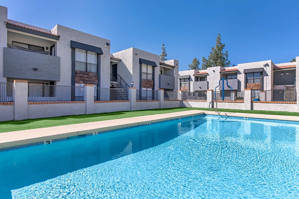 a swimming pool with apartments in the background