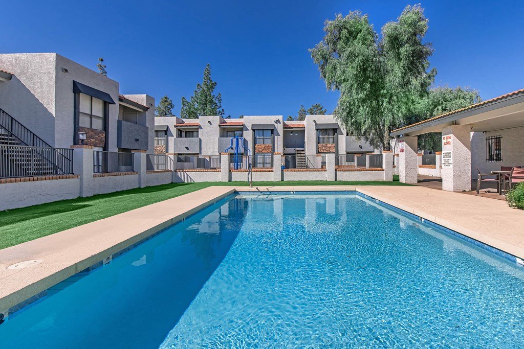 a large swimming pool with apartments in the background