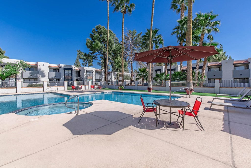 our apartments have a pool and a patio with chairs and umbrellas