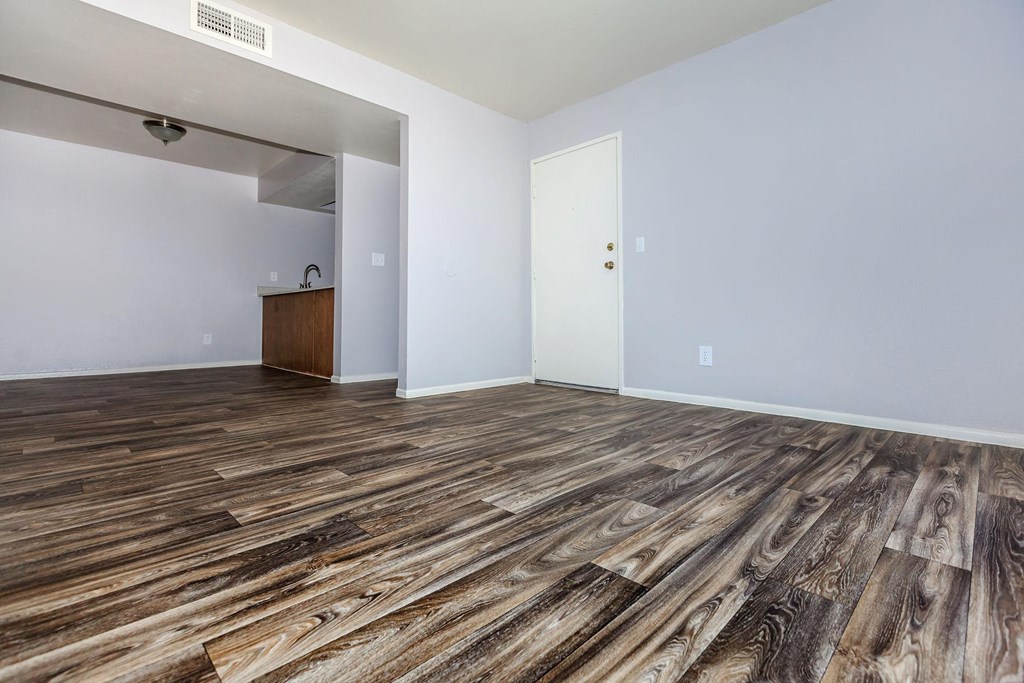 the living room of an empty apartment with wood flooring