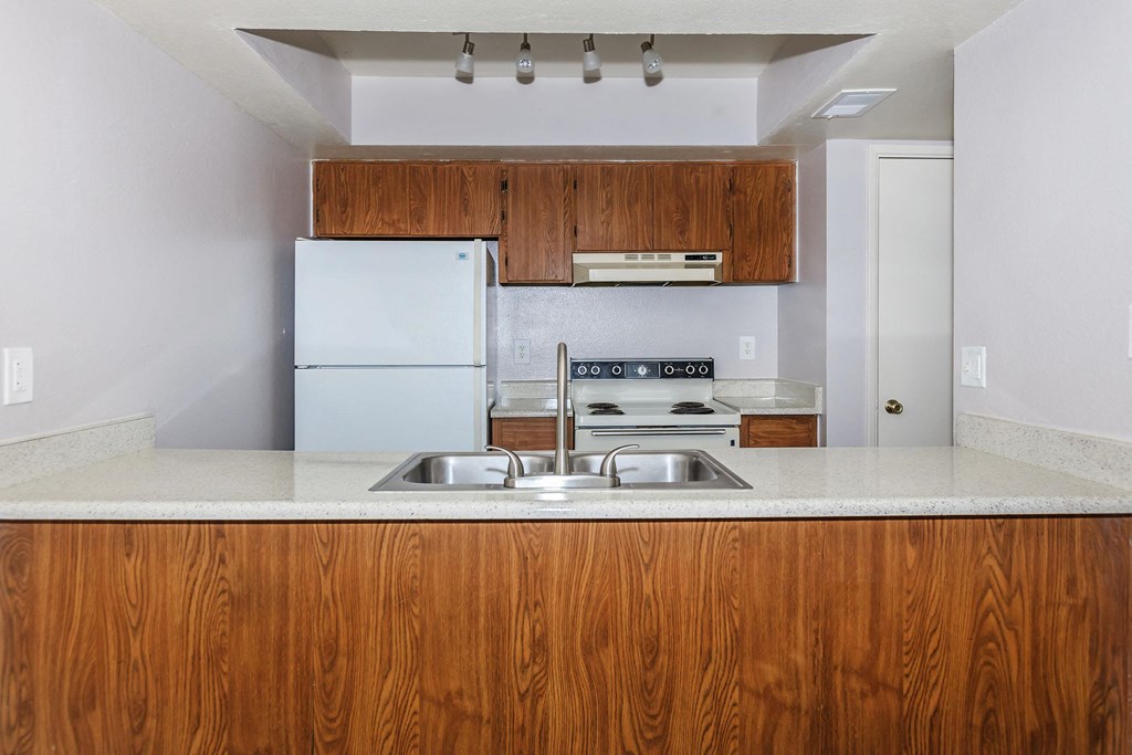 a kitchen with white appliances and wooden cabinets