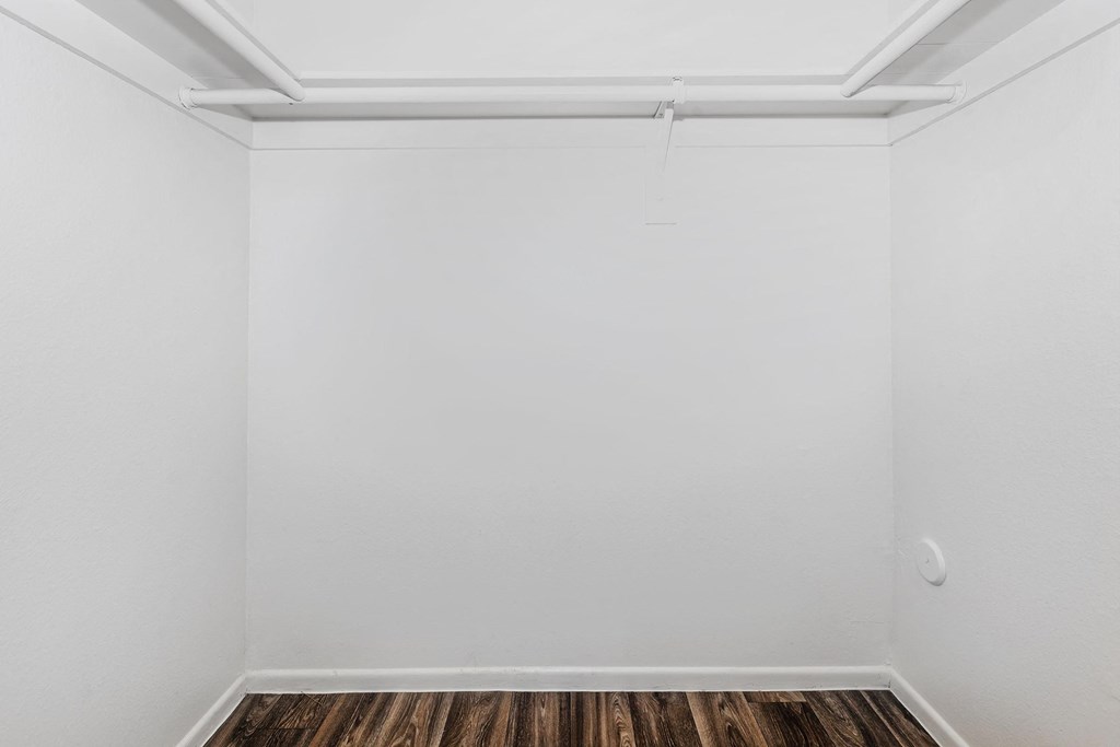 an empty room with white walls and wooden floors