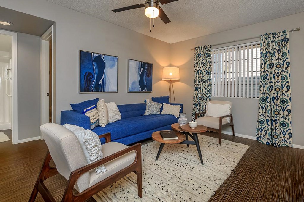 a living room with a blue couch and chairs