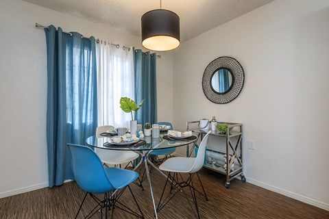a dining room with a glass table and chairs