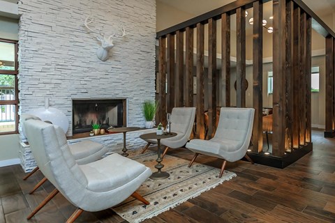 a living room with chairs and a fireplace