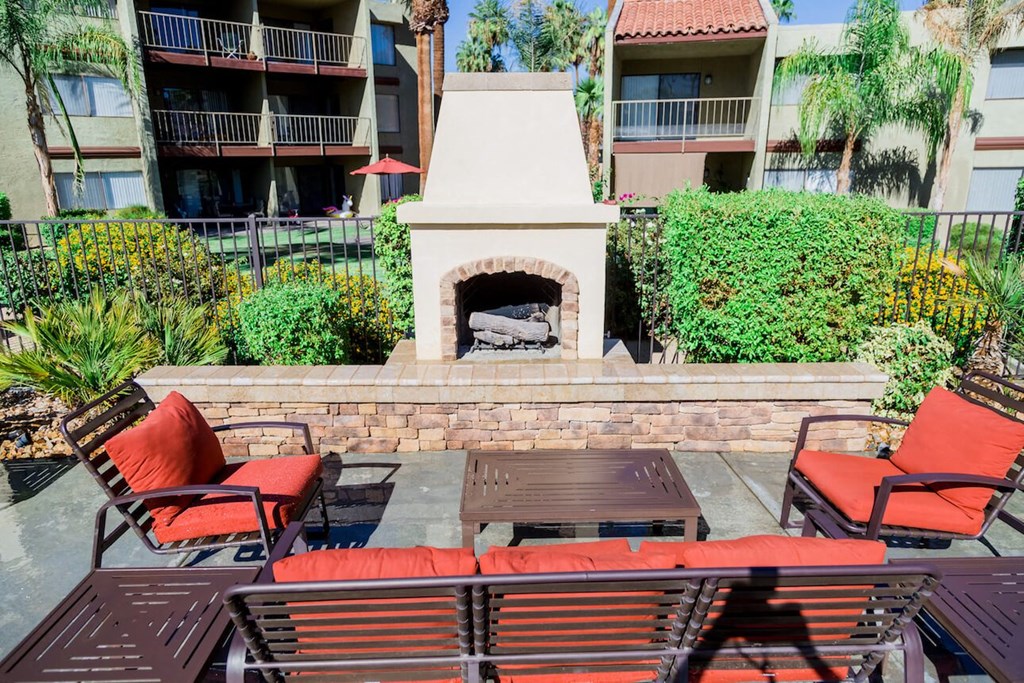 a patio with a fireplace and a table and chairs