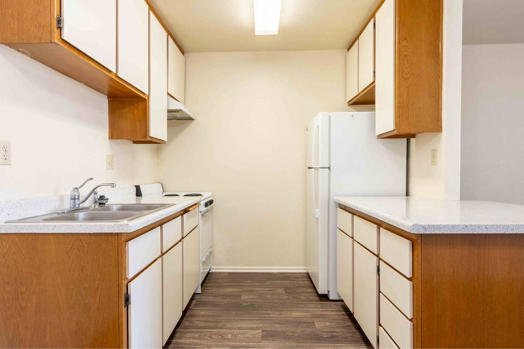 a kitchen with white cabinets and a sink and a refrigerator