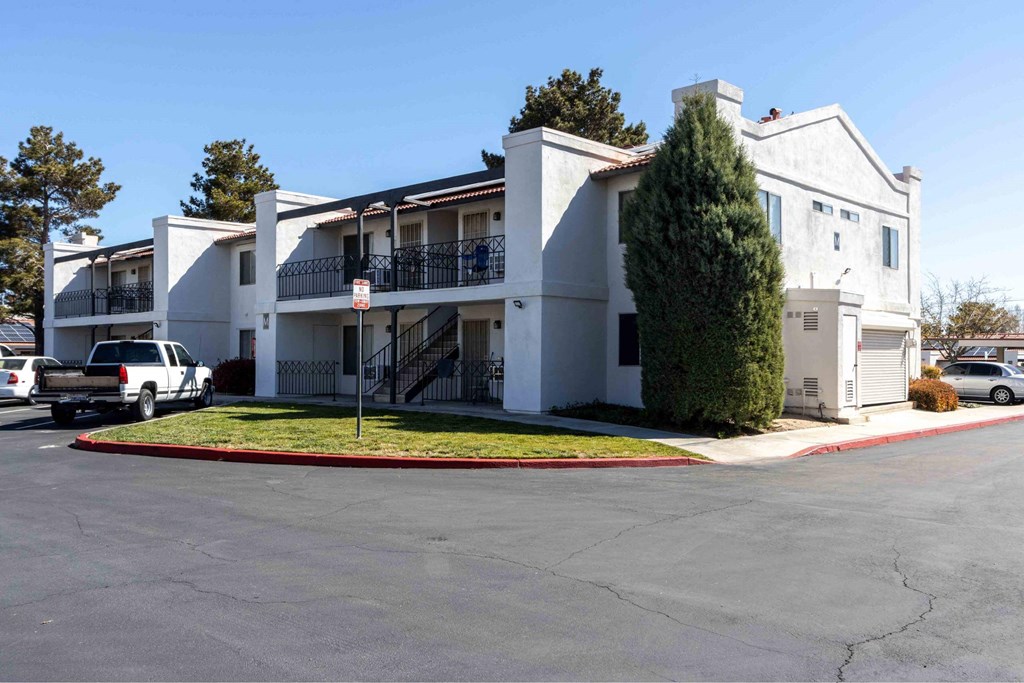 a white apartment building with a parking lot