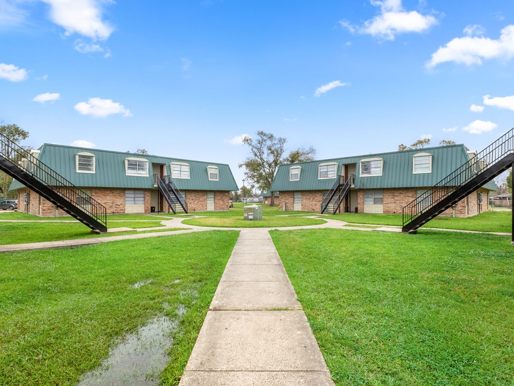 a pathway leading up to a row of houses with green roofs