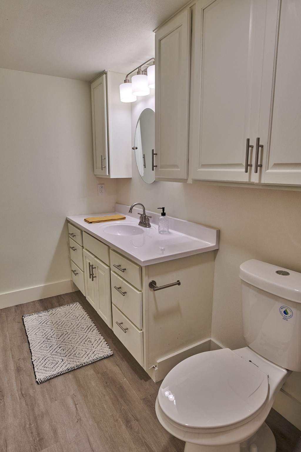a bathroom with white cabinets and a white toilet and sink