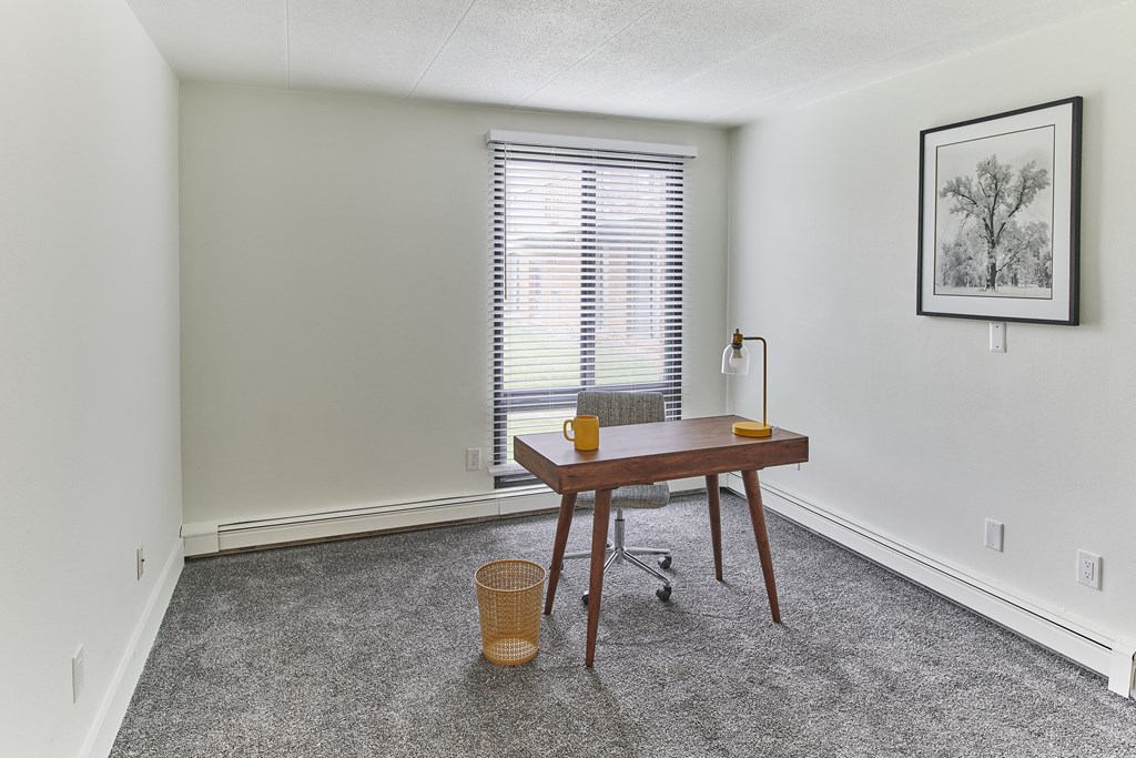 a home office with a desk and a window