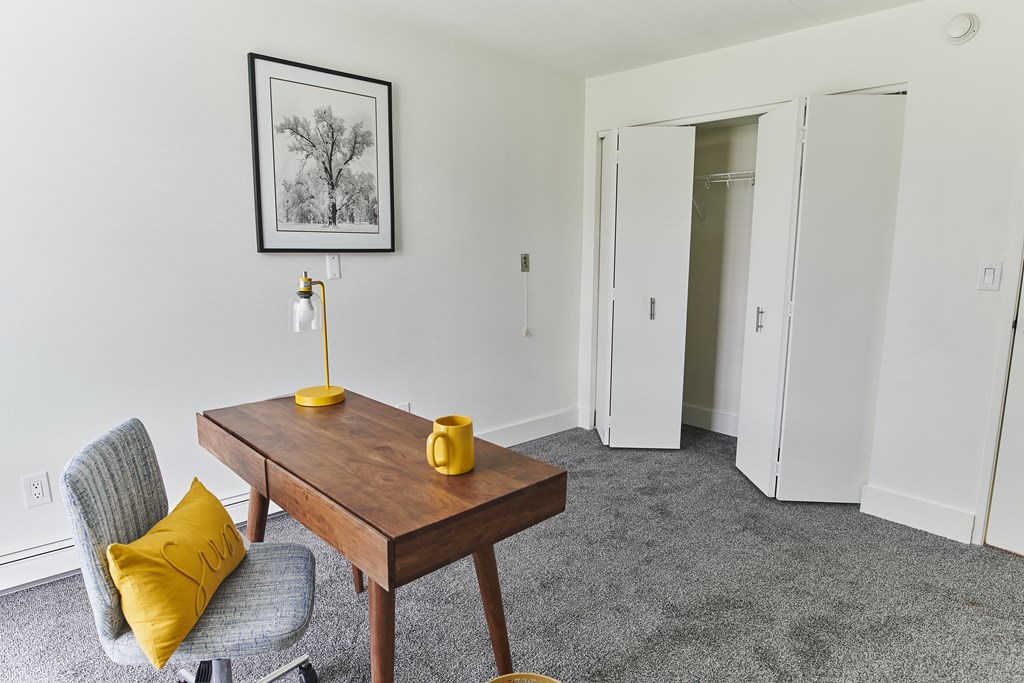 a living room with a table and a chair and a closet