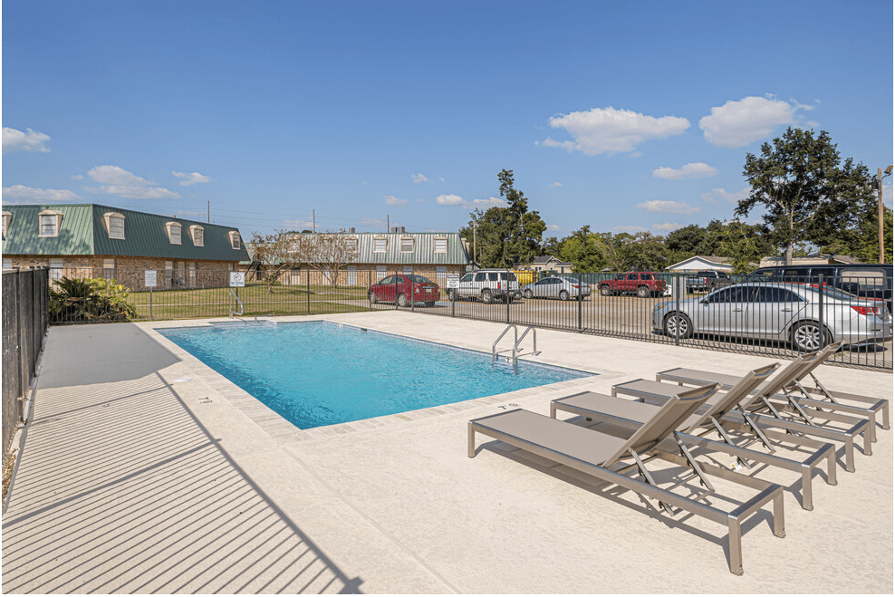 a swimming pool with chaise lounge chairs next to a pool