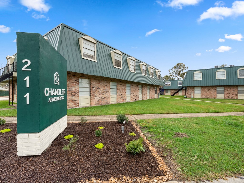 a green building with a sign that reads 2 chandler apartments