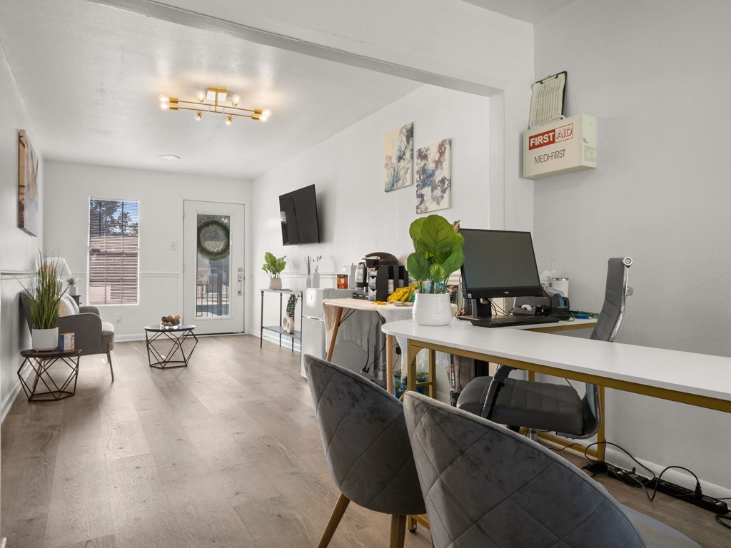 a home office with a desk and chairs and a computer