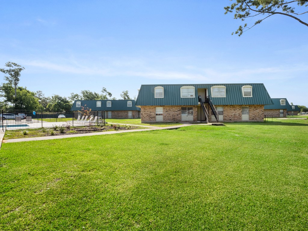 a house with a green roof and a lawn in front of it