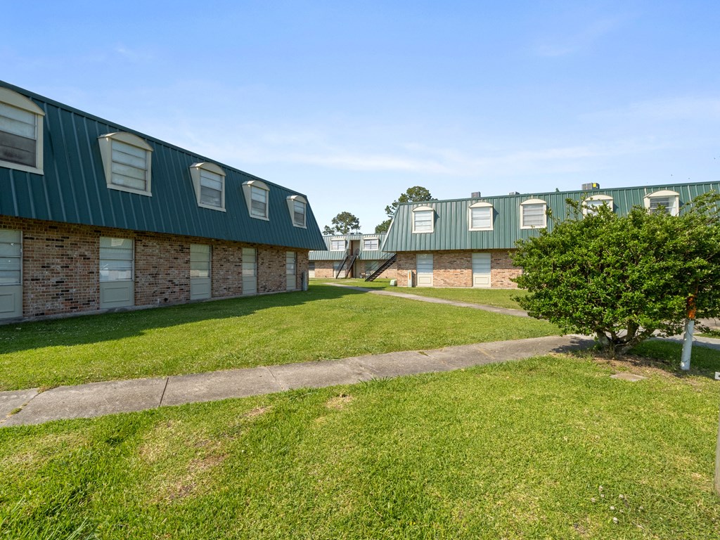 an exterior view of a brick building with green roofs