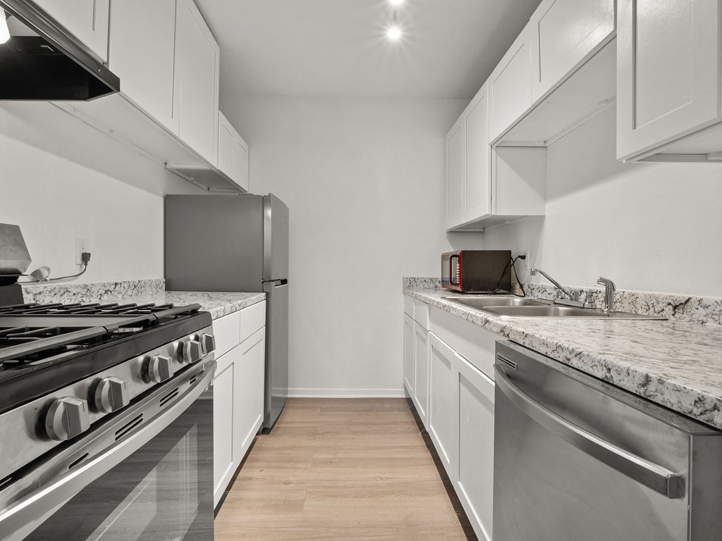 a kitchen with marble counter tops and stainless steel appliances