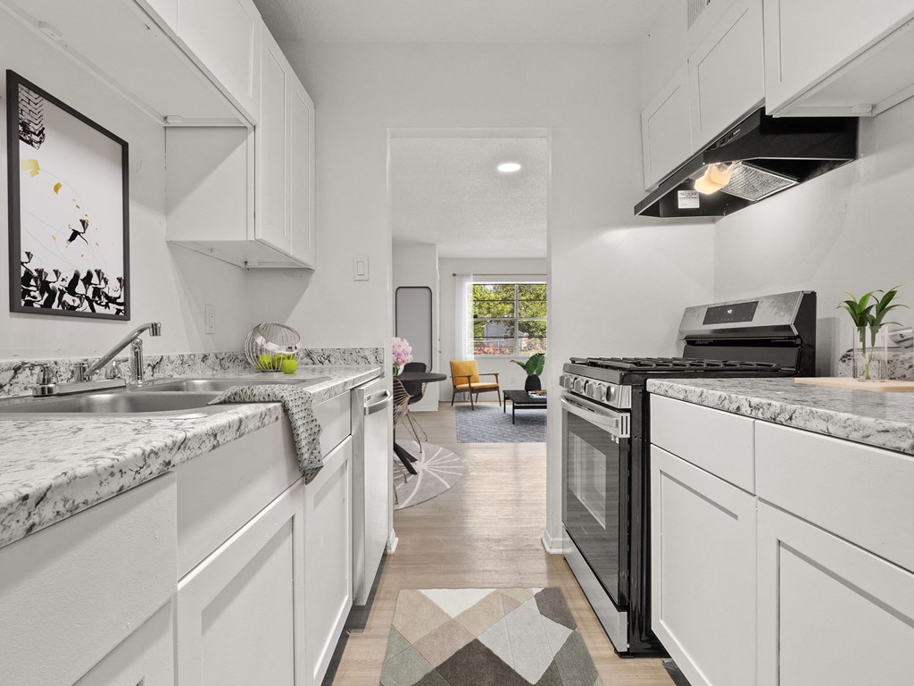 a white kitchen with marble counter tops and white cabinets