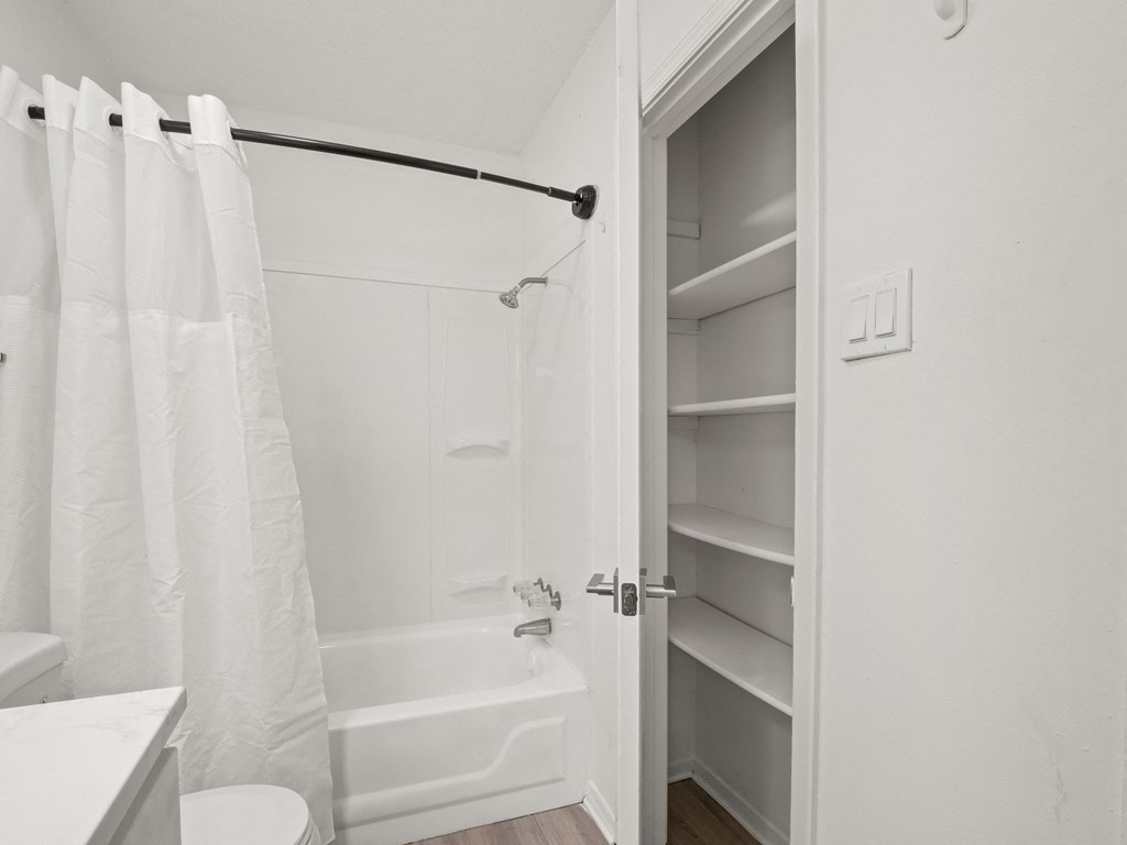 a small bathroom with a shower and a closet