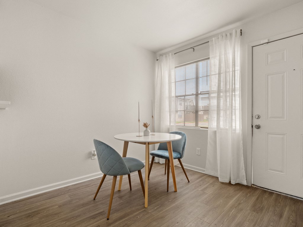 a dining room with a table and chairs and a window
