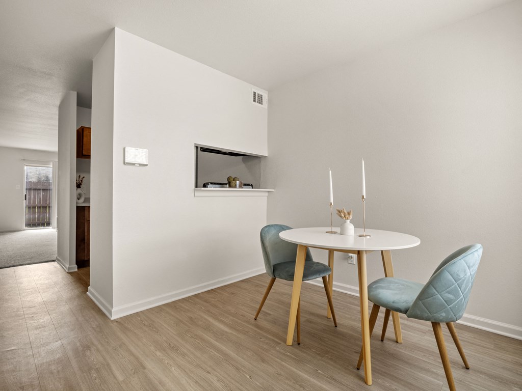 a dining room with a small table and chairs and a microwave
