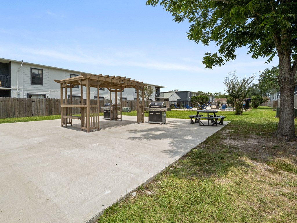 a picnic area in a park with benches and a gazebo