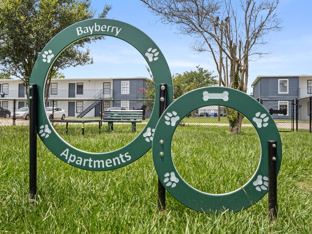 a sign for the city of bayery apartments in a park