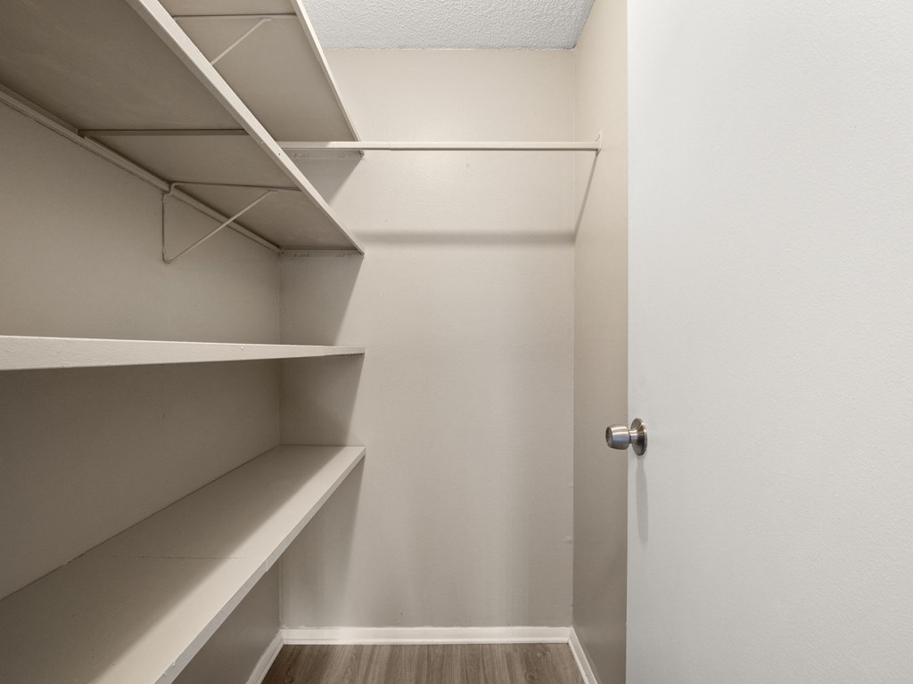 a walk in closet with shelves and a door