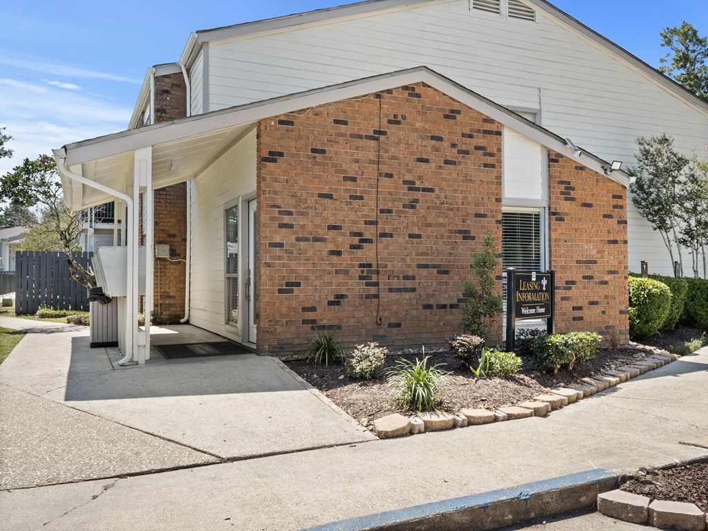 the front of a brick house with a sidewalk in front of it
