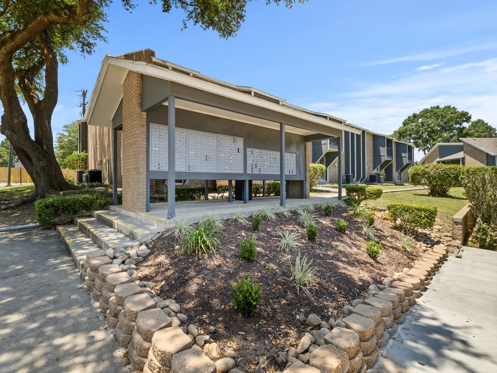 a building with a stone facade and a sidewalk in front of it