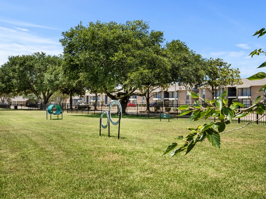 a park with a playground and trees in front of an apartment building