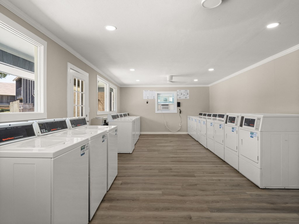 an empty laundry room with washes and dryers in it