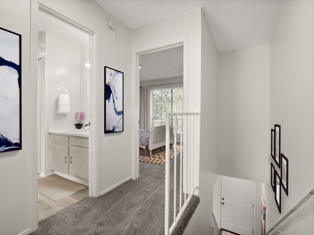 a white room with a staircase and a door to a bedroom