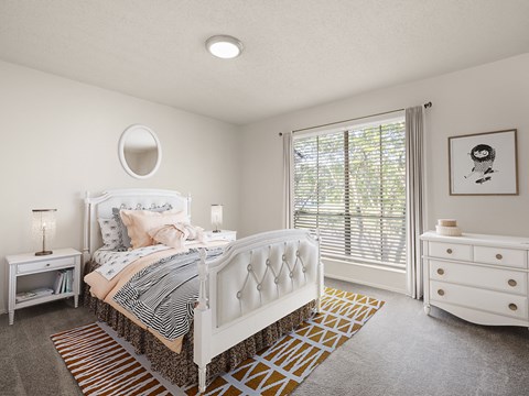 a white bedroom with a bed and a window