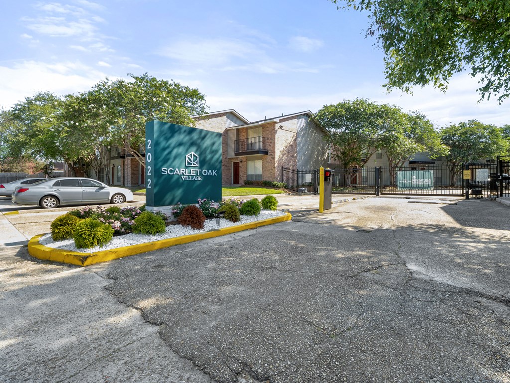 a parking lot with a sign in front of an apartment building
