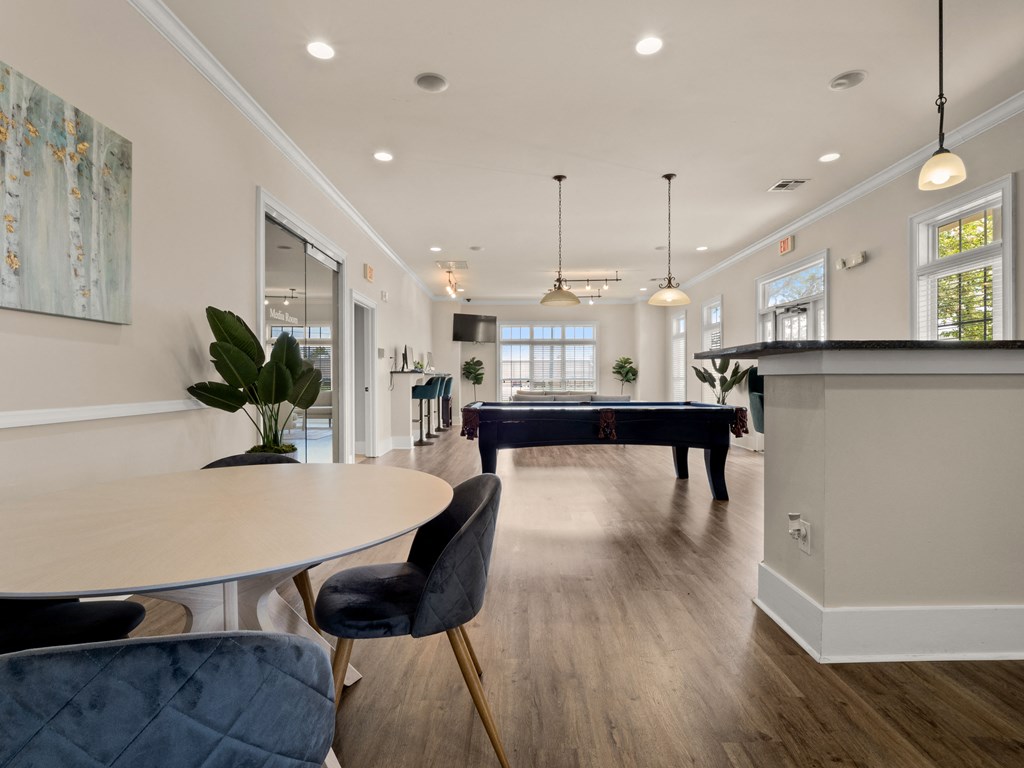 a game room with a pool table and a dining room table