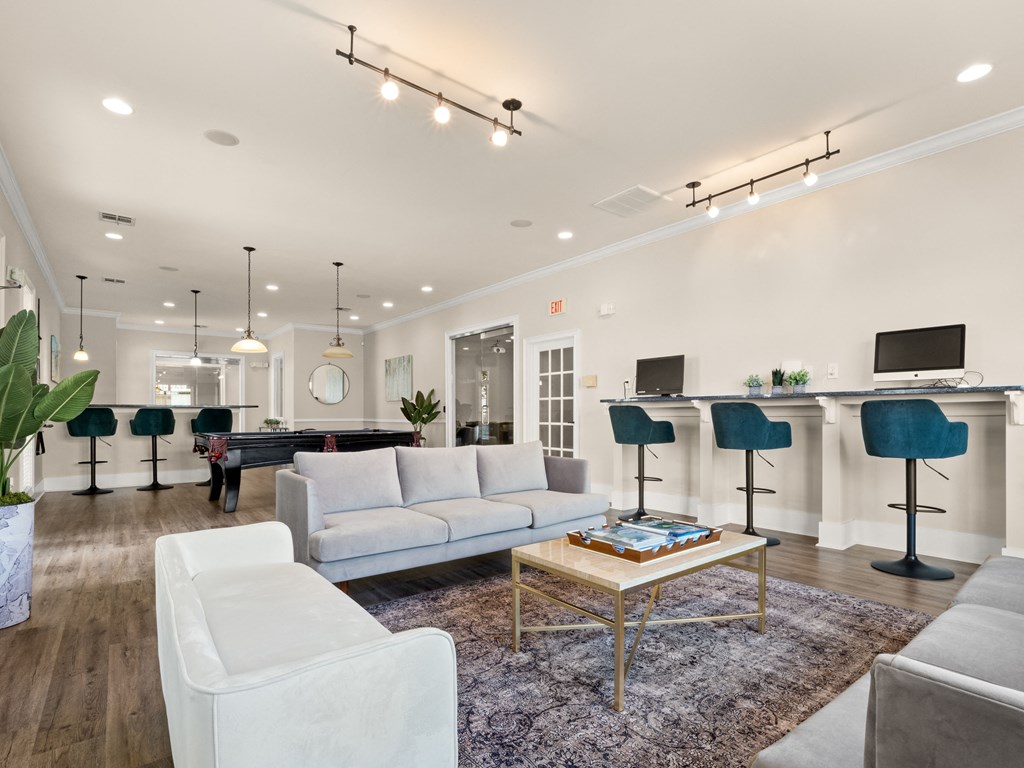 a living room with couches and chairs and a bar and a television