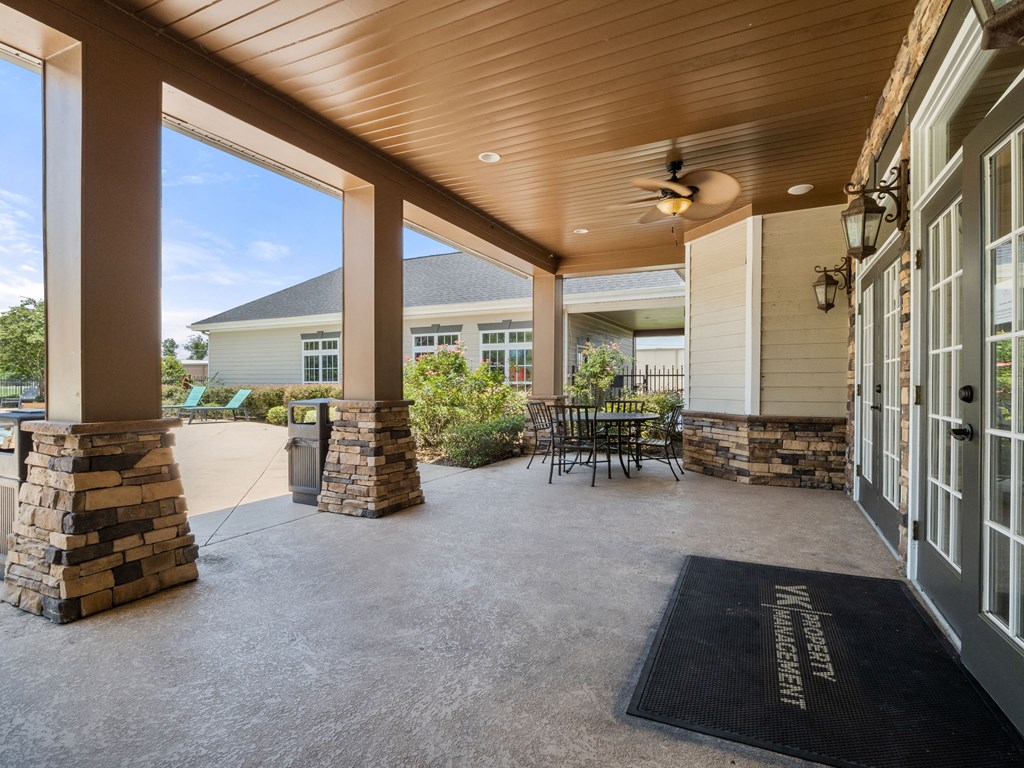 the front porch of a house with chairs and a table