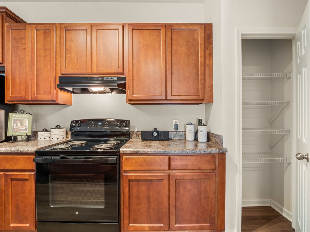 a kitchen with wood cabinets and black appliances and granite counter tops