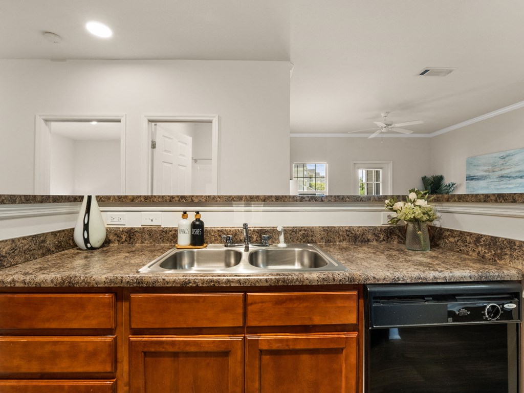 a kitchen with granite counter tops and a stainless steel sink
