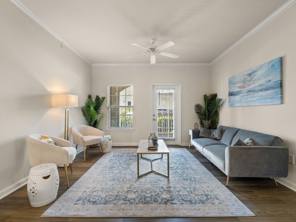 a living room with a couch and chairs and a ceiling fan