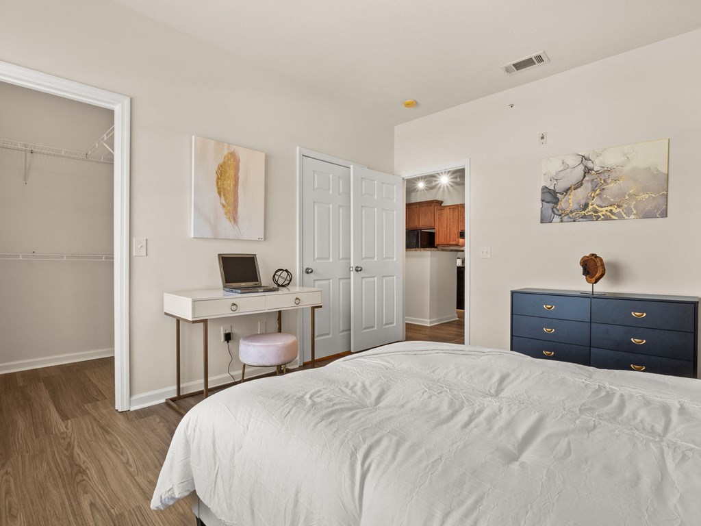 a bedroom with a bed and a desk with a laptop