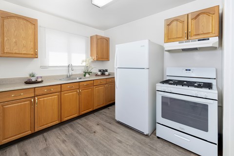 A kitchen with wooden cabinets and white appliances.