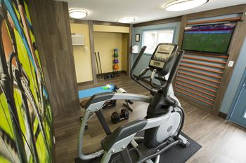 fitness center with elliptical and tv at Abby Creek Apartments, California, 95608