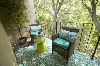 Model Apartment patio with wicker chairs and a table at Abby Creek Apartments, Carmichael, CA 95608 