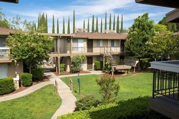Apartment building with a green lawn and trees at Abby Creek Apartments, California 