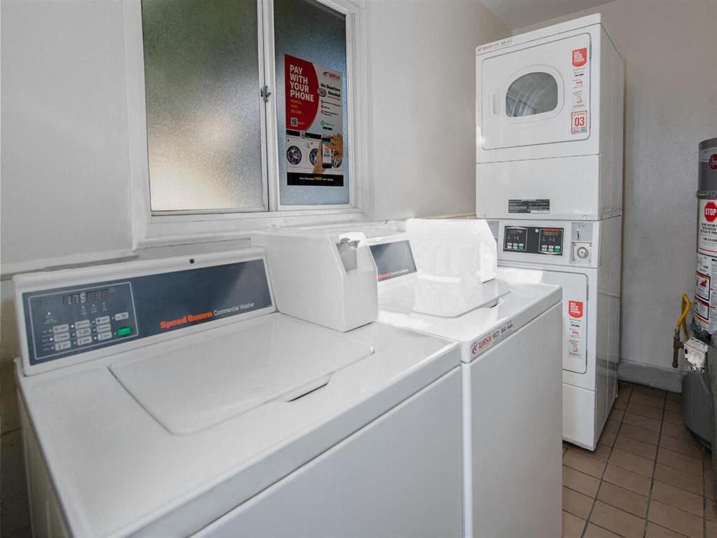 a laundry room with two washing machines and two microwaves