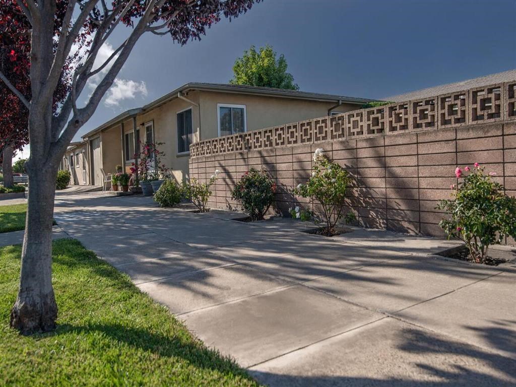 a building with a sidewalk and a tree in front of it