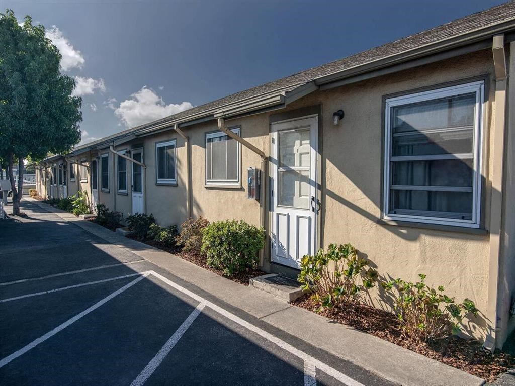 a row of houses with white doors and windows on a street